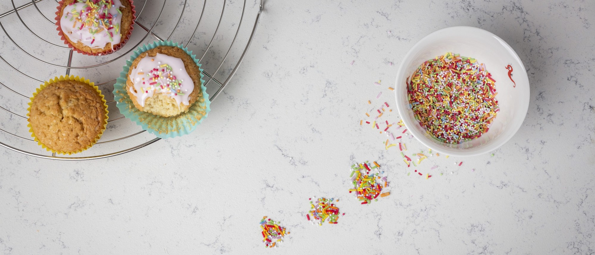Cupcakes met de decoratie verspreid over het aanrechtblad